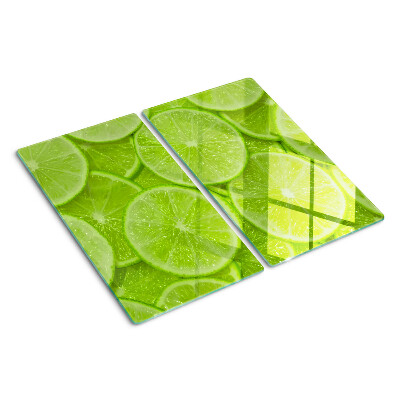 Glas skærebræt Limeskiver på en grøn baggrund