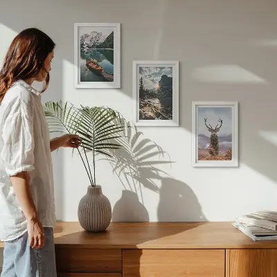 Billedvæg med rammer motiv af bjergsø, båd, solnedgang og hjorte i naturen