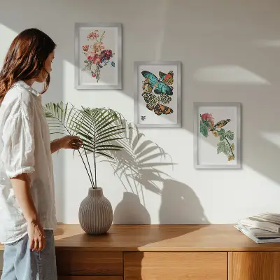 Billeder og rammer med motiver af blomster, sommerfugle og en fugl i pastelfarver