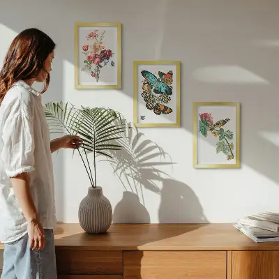 Billeder og rammer med motiver af blomster, sommerfugle og en fugl i pastelfarver