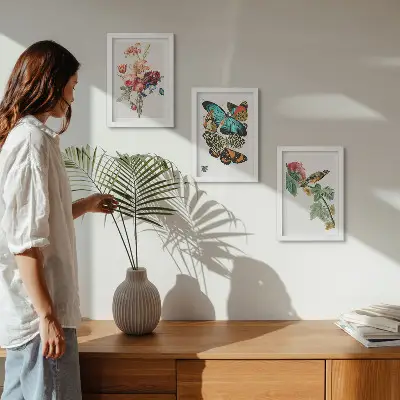 Billeder og rammer med motiver af blomster, sommerfugle og en fugl i pastelfarver