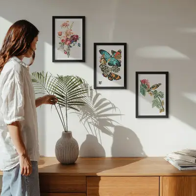 Billeder og rammer med motiver af blomster, sommerfugle og en fugl i pastelfarver
