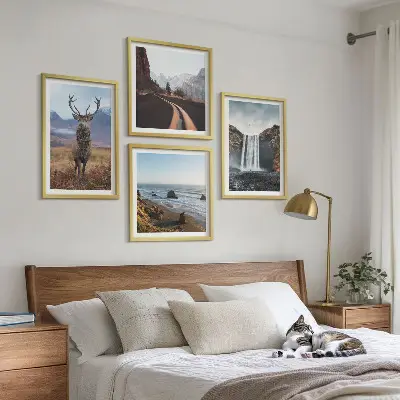 Billedvæg over sofa med bjerglandskaber, vandfald, hjorte og strande