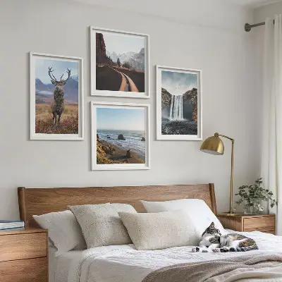 Billedvæg over sofa med bjerglandskaber, vandfald, hjorte og strande