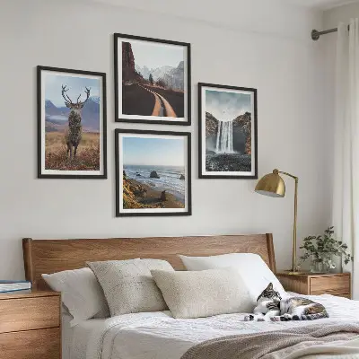 Billedvæg over sofa med bjerglandskaber, vandfald, hjorte og strande