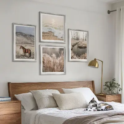 Billedvæg over sofa med motiv af heste i et landskab med søgræs og skov