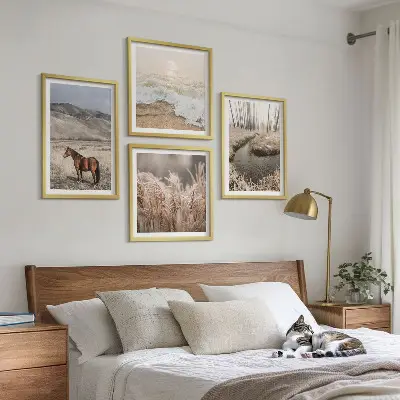 Billedvæg over sofa med motiv af heste i et landskab med søgræs og skov