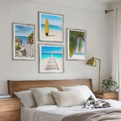 Billedvæg over sofa med motiv af ferieudsigt over strand og palmer