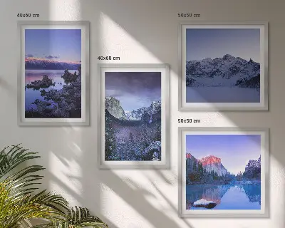 Billedvæg over sofa med bjerglandskaber, solnedgang og vand