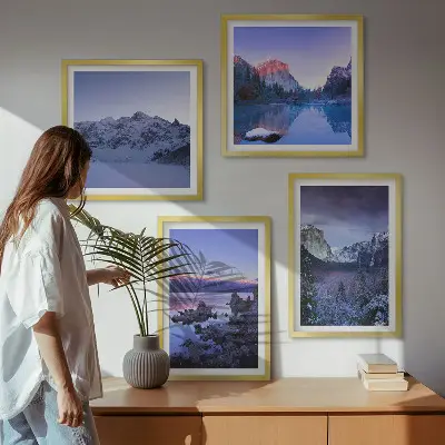 Billedvæg over sofa med bjerglandskaber, solnedgang og vand