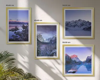 Billedvæg over sofa med bjerglandskaber, solnedgang og vand