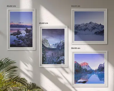 Billedvæg over sofa med bjerglandskaber, solnedgang og vand