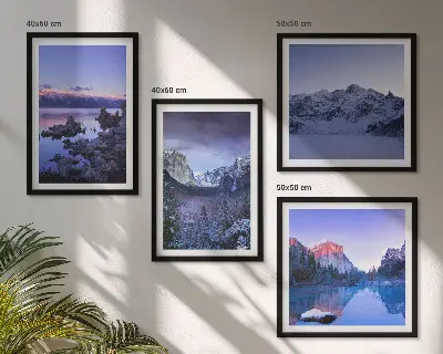 Billedvæg over sofa med bjerglandskaber, solnedgang og vand