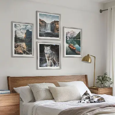 Billedvæg over sofa med motiver af bjerge, søer, vandfald og en ulv