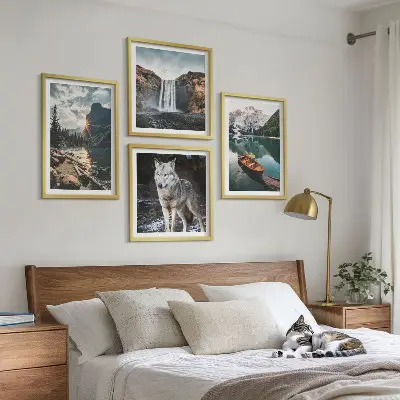 Billedvæg over sofa med motiver af bjerge, søer, vandfald og en ulv