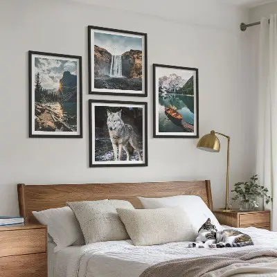 Billedvæg over sofa med motiver af bjerge, søer, vandfald og en ulv