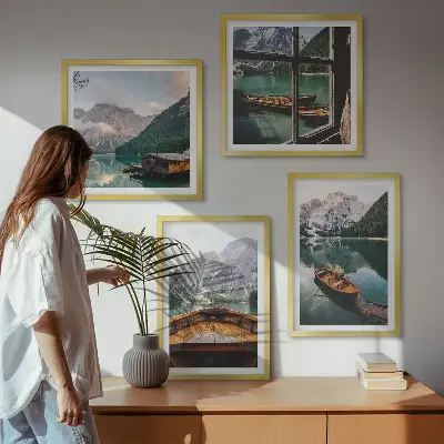 Billedvæg over sofa med motiv af sø, bjerge, både og sommerhus ved vinduet