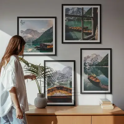 Billedvæg over sofa med motiv af sø, bjerge, både og sommerhus ved vinduet