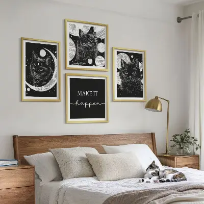Billedvæg over sofa med motiv af sorte katte og måneplanet