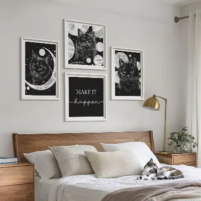 Billedvæg over sofa med motiv af sorte katte og måneplanet