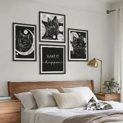 Billedvæg over sofa med motiv af sorte katte og måneplanet