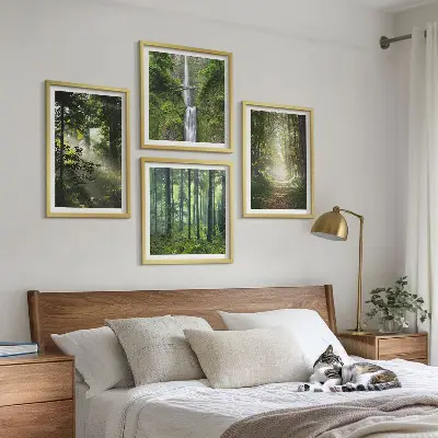 Billedvæg over sofa med motiv af grønne skove med lysstråler