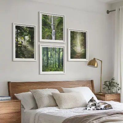 Billedvæg over sofa med motiv af grønne skove med lysstråler