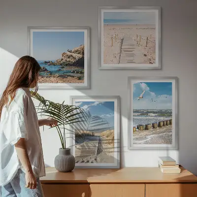 Billedvæg over sofa med motiv af strand, sand, bølger, himmel og fugle