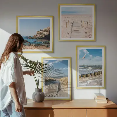 Billedvæg over sofa med motiv af strand, sand, bølger, himmel og fugle