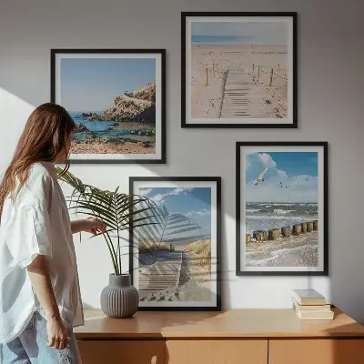 Billedvæg over sofa med motiv af strand, sand, bølger, himmel og fugle
