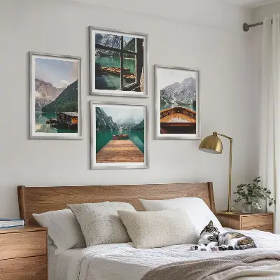 Billedvæg over sofa med bjerglandskaber og hyttebåde