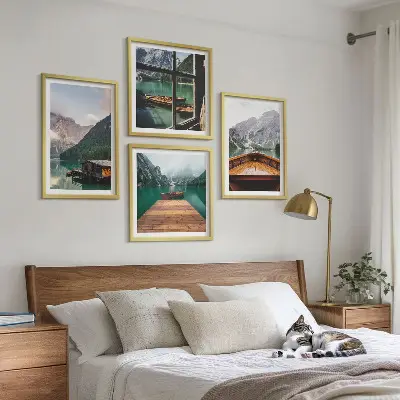 Billedvæg over sofa med bjerglandskaber og hyttebåde