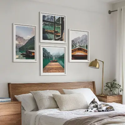Billedvæg over sofa med bjerglandskaber og hyttebåde