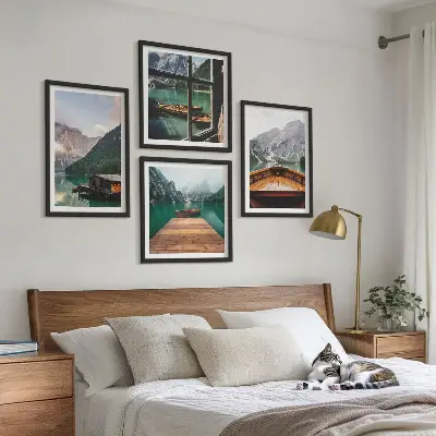 Billedvæg over sofa med bjerglandskaber og hyttebåde