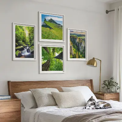 Billedvæg over sofa med motiv af grønne bjerge, vandfald og skov
