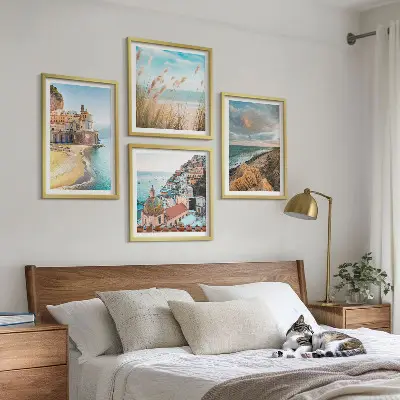 Billedvæg over sofa med landskaber af strand og klipper