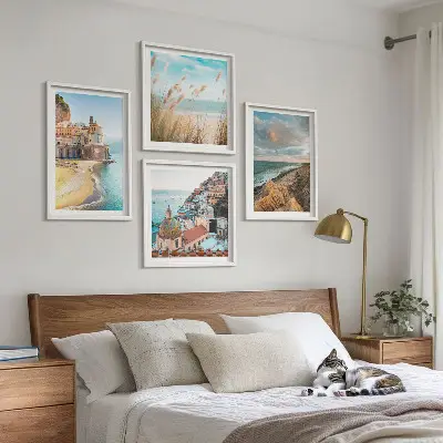 Billedvæg over sofa med landskaber af strand og klipper