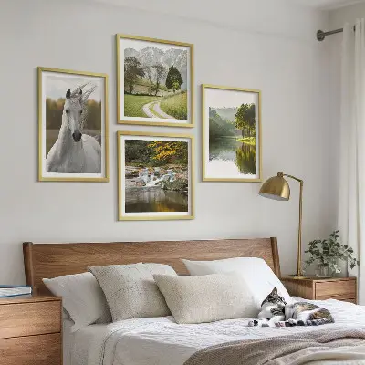 Billedvæg over sofa med motiv af hvide heste ved en flod i naturen