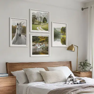 Billedvæg over sofa med motiv af hvide heste ved en flod i naturen