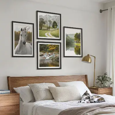 Billedvæg over sofa med motiv af hvide heste ved en flod i naturen