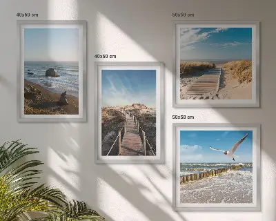 Billedvæg over sofa med motiv af strand bølger himmel og mole