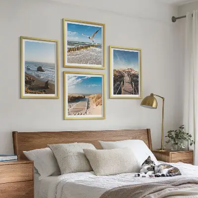 Billedvæg over sofa med motiv af strand bølger himmel og mole