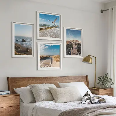 Billedvæg over sofa med motiv af strand bølger himmel og mole