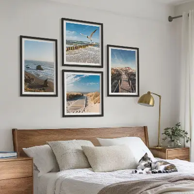 Billedvæg over sofa med motiv af strand bølger himmel og mole