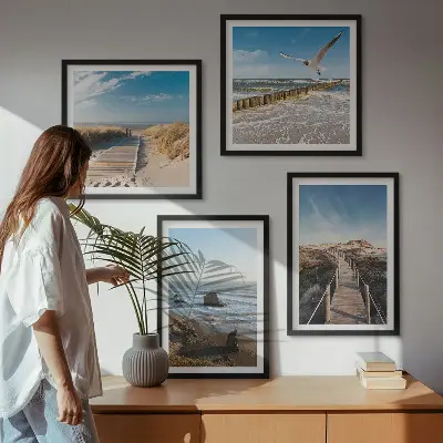 Billedvæg over sofa med motiv af strand bølger himmel og mole