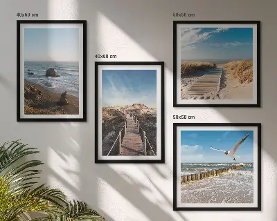 Billedvæg over sofa med motiv af strand bølger himmel og mole