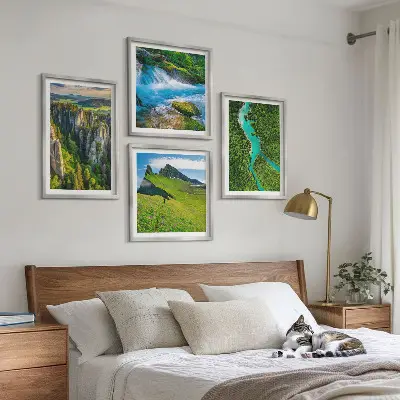 Billedvæg over sofa med motiv af grønne bjerge og flodklipper
