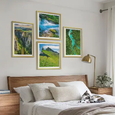 Billedvæg over sofa med motiv af grønne bjerge og flodklipper