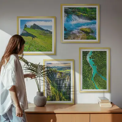Billedvæg over sofa med motiv af grønne bjerge og flodklipper