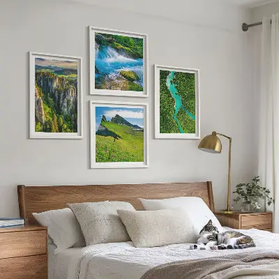 Billedvæg over sofa med motiv af grønne bjerge og flodklipper